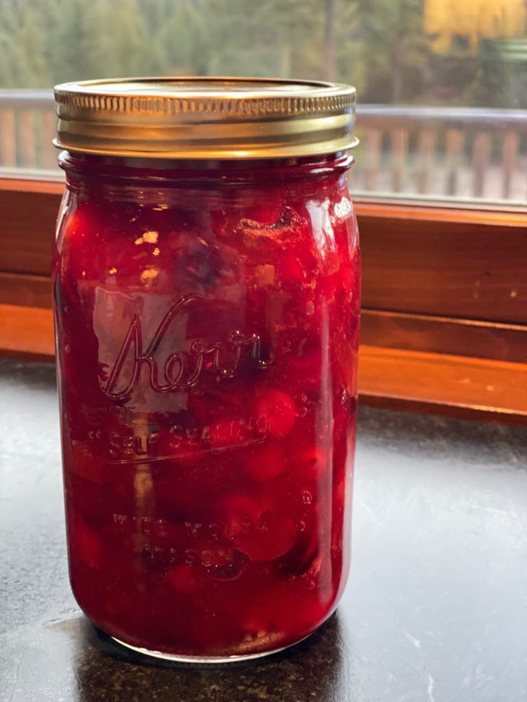 a canning jar filed with cranberry sauce 