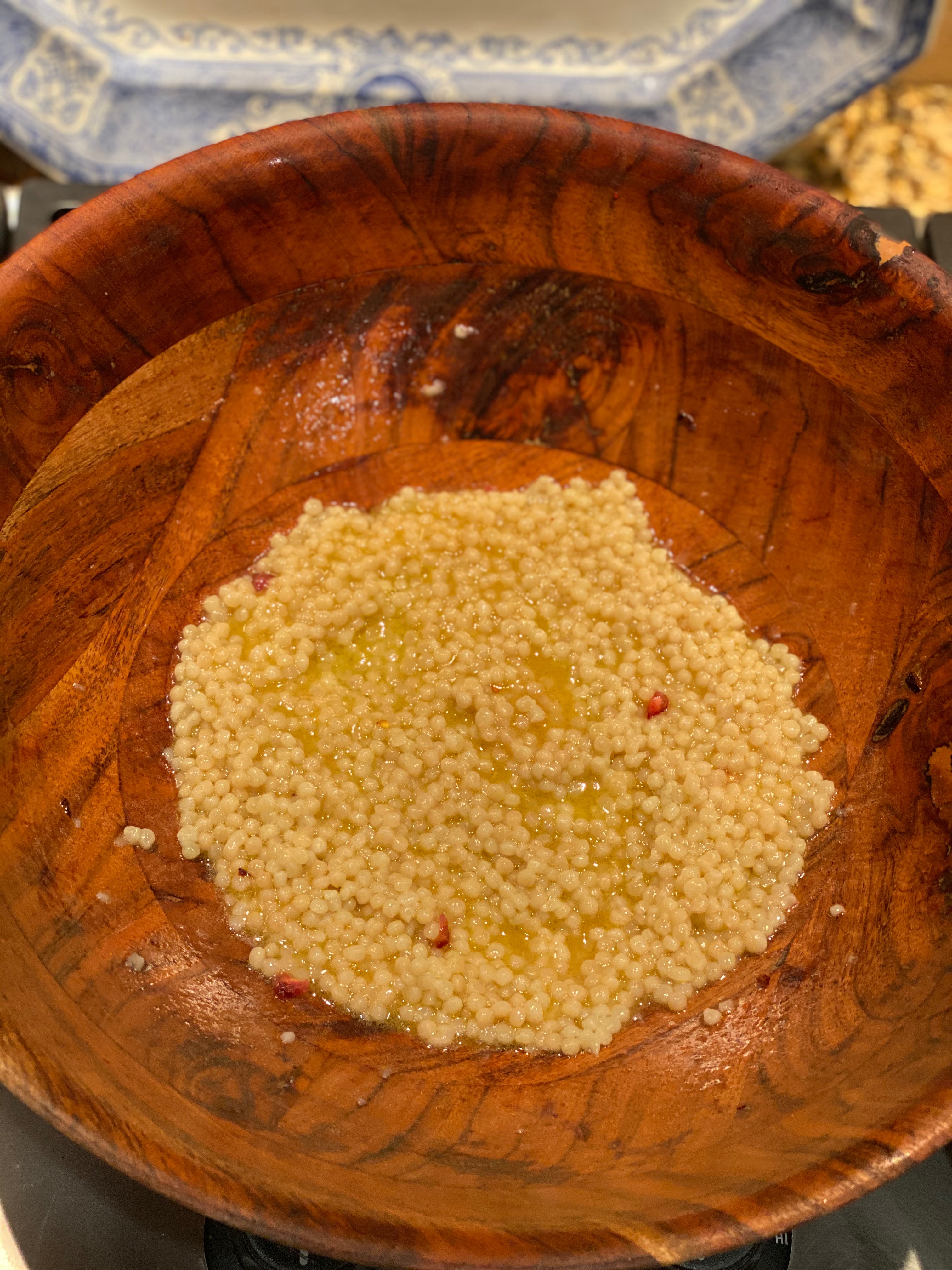 a large wooden salad bowl with cooked couscous 