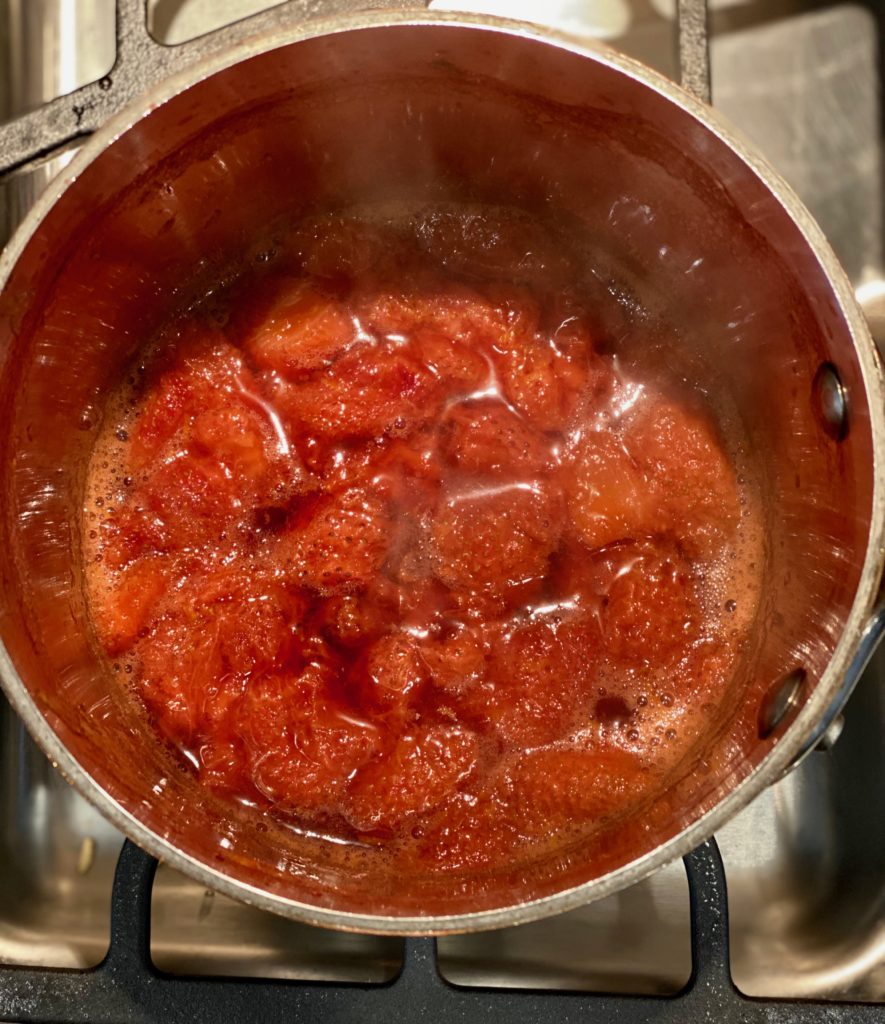 A saucepan with strawberries cooked and jammy 