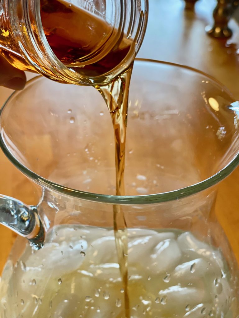 a shot of grand mariner being poured into a pitcher