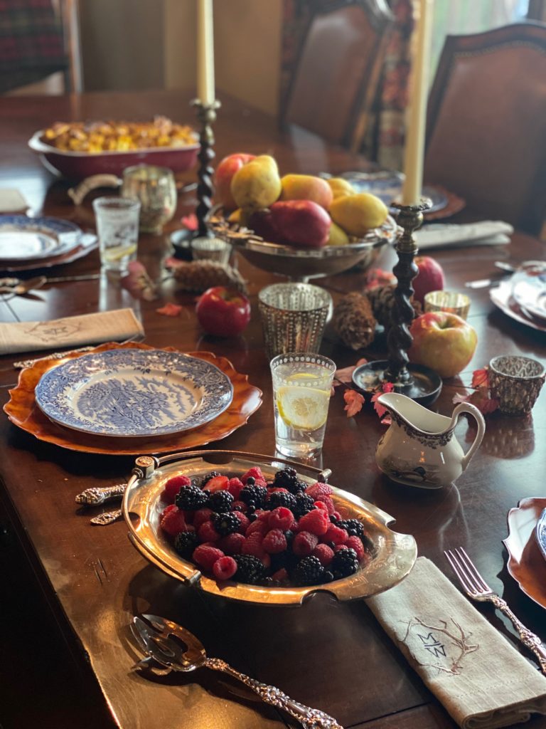a wooden table set with fine china and silver
