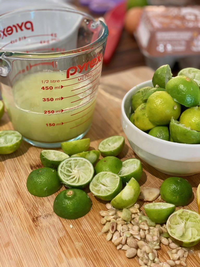250ml of lime juice and a pile of limes that have been juiced 