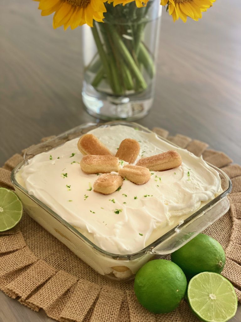 a glass dish filled with a creamy custard surrounded by limes