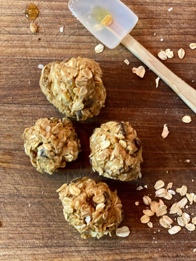 oatmeal and peanut butter balls with a small spatula on a wooden board 