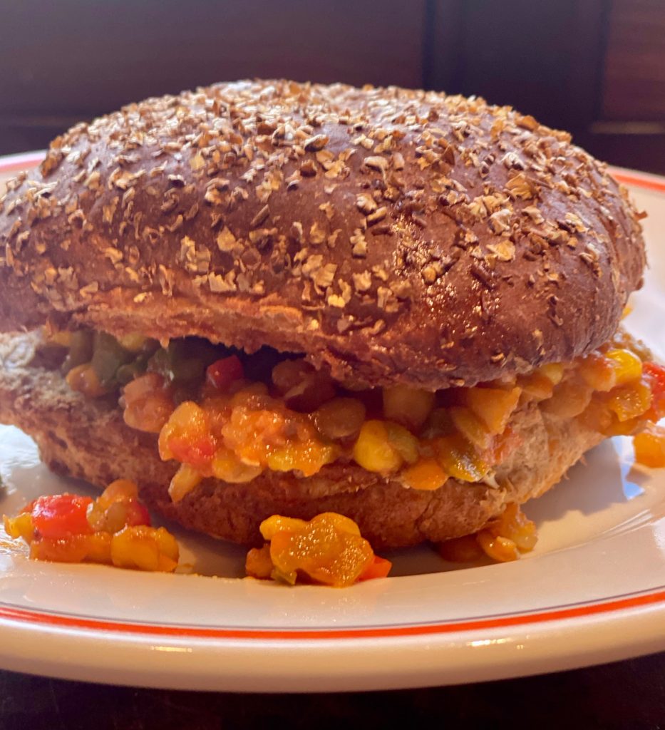 a large hamburger bun stuffed with a lentil sloppy how mixture