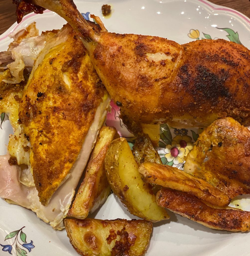 a roasted chicken with potatoes 