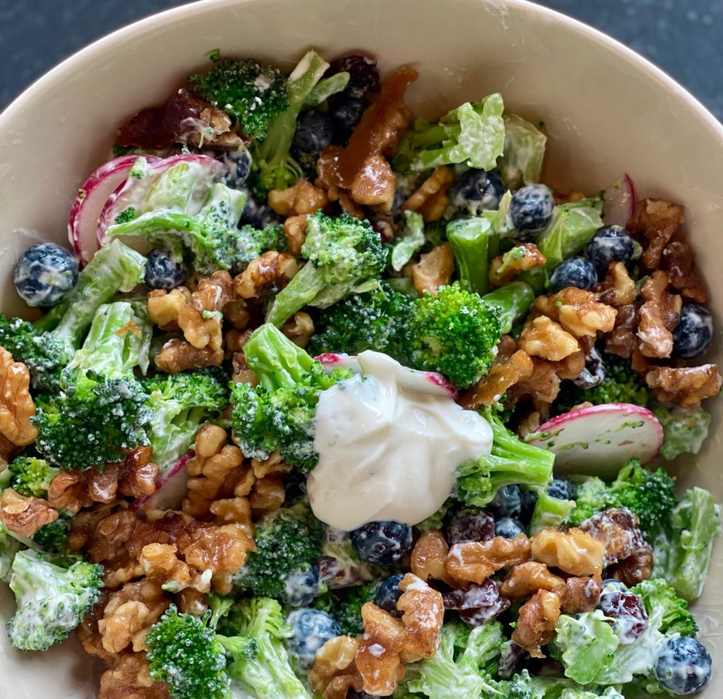 a bowl of broccoli, radishes, blueberries and toasted walnuts 