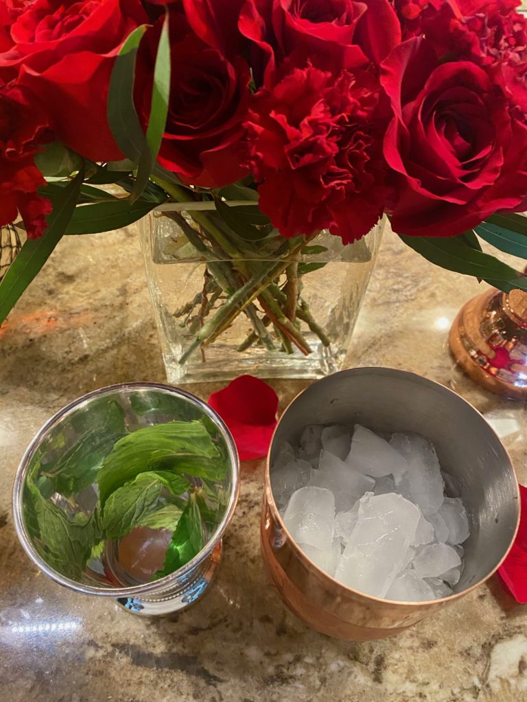 a mint julep cup and a cocktail shaker filled with ice