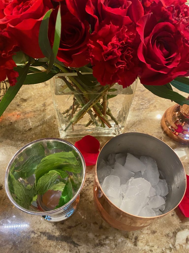 a mint julep cup and a cocktail shaker filled with ice 