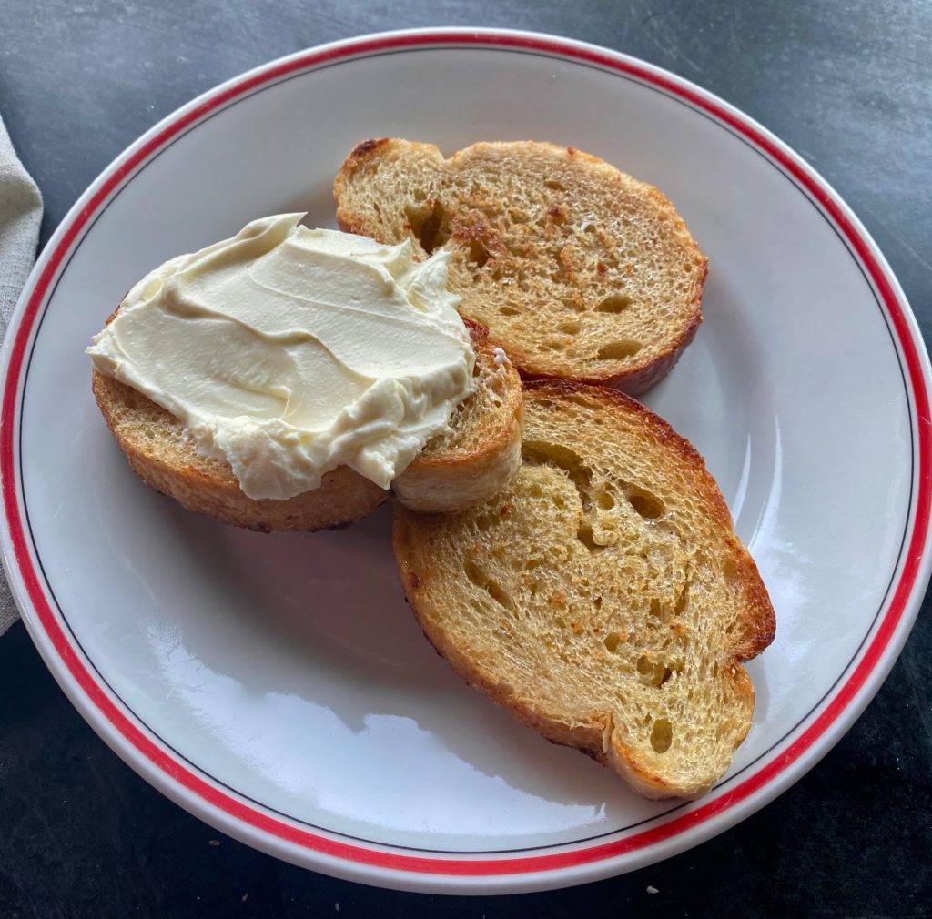 plain toast with ricotta cheese spread on it 
