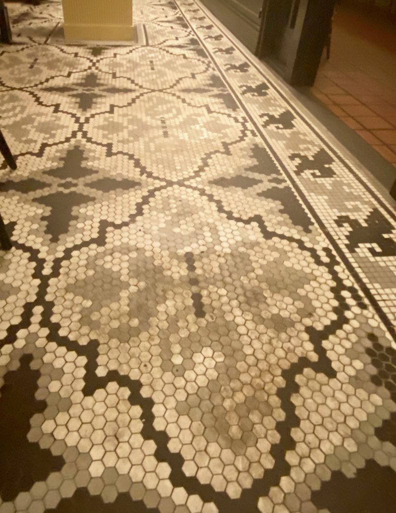 a close up of the mosaic tile work on the hotel lobby floor 