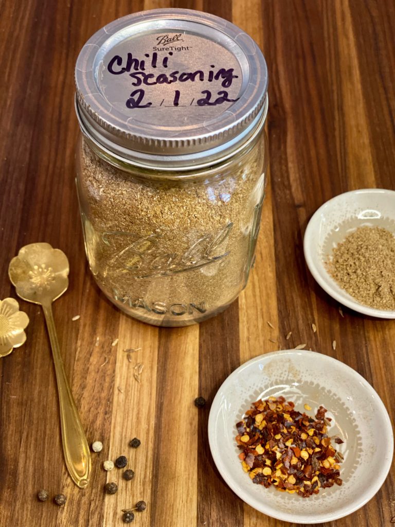 a jar filled with spices on a wooden board 
