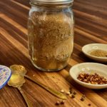 a glass jar filled with taco seasonings on a wooden board