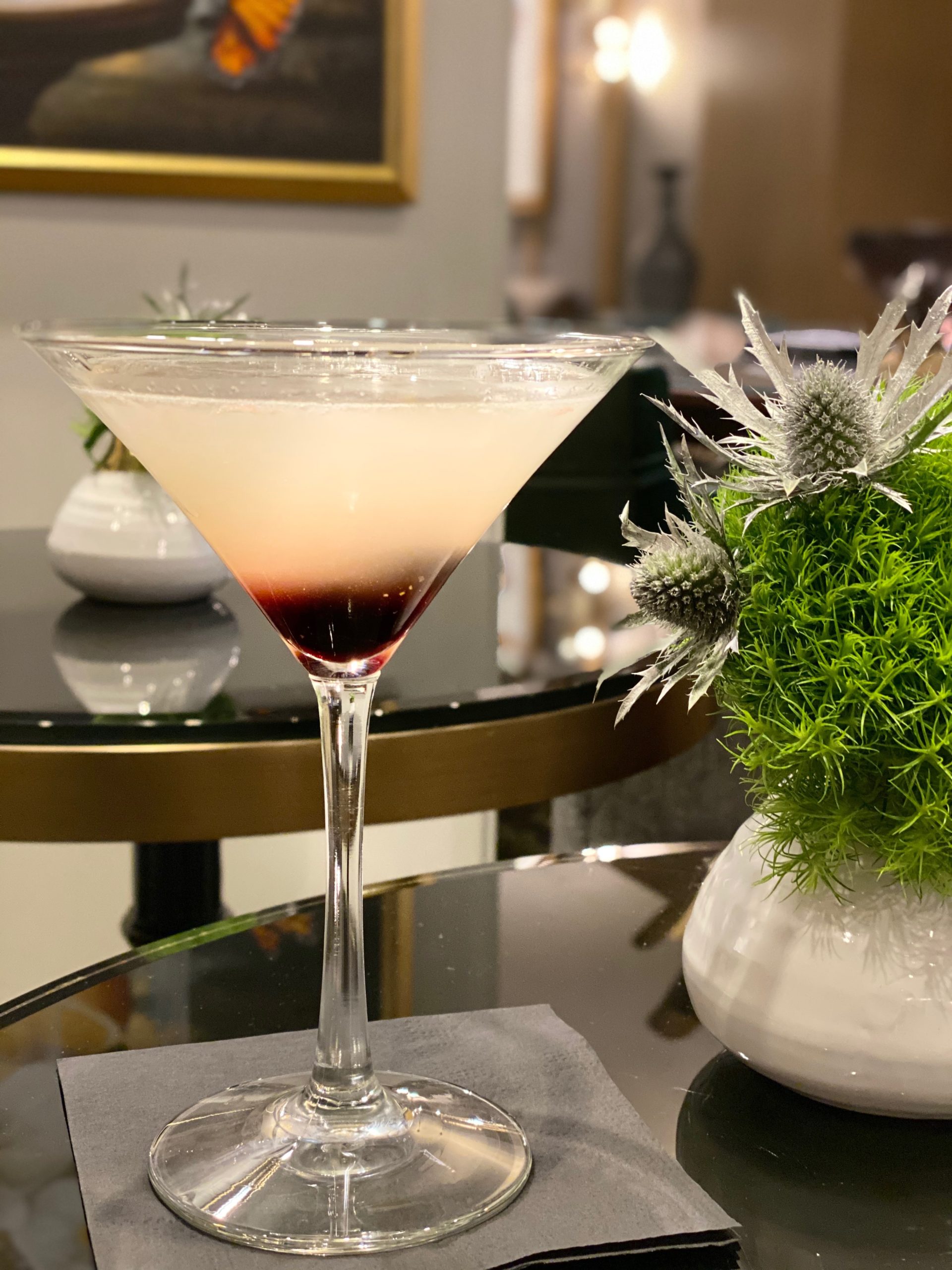 An elegant martini glass filled with a two tone cocktail