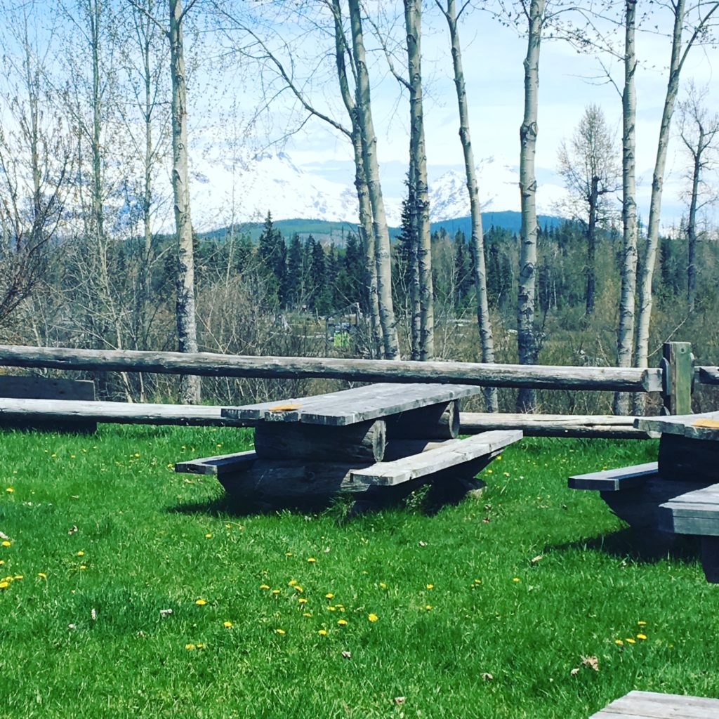 A wooden picnic table with a view of mountains