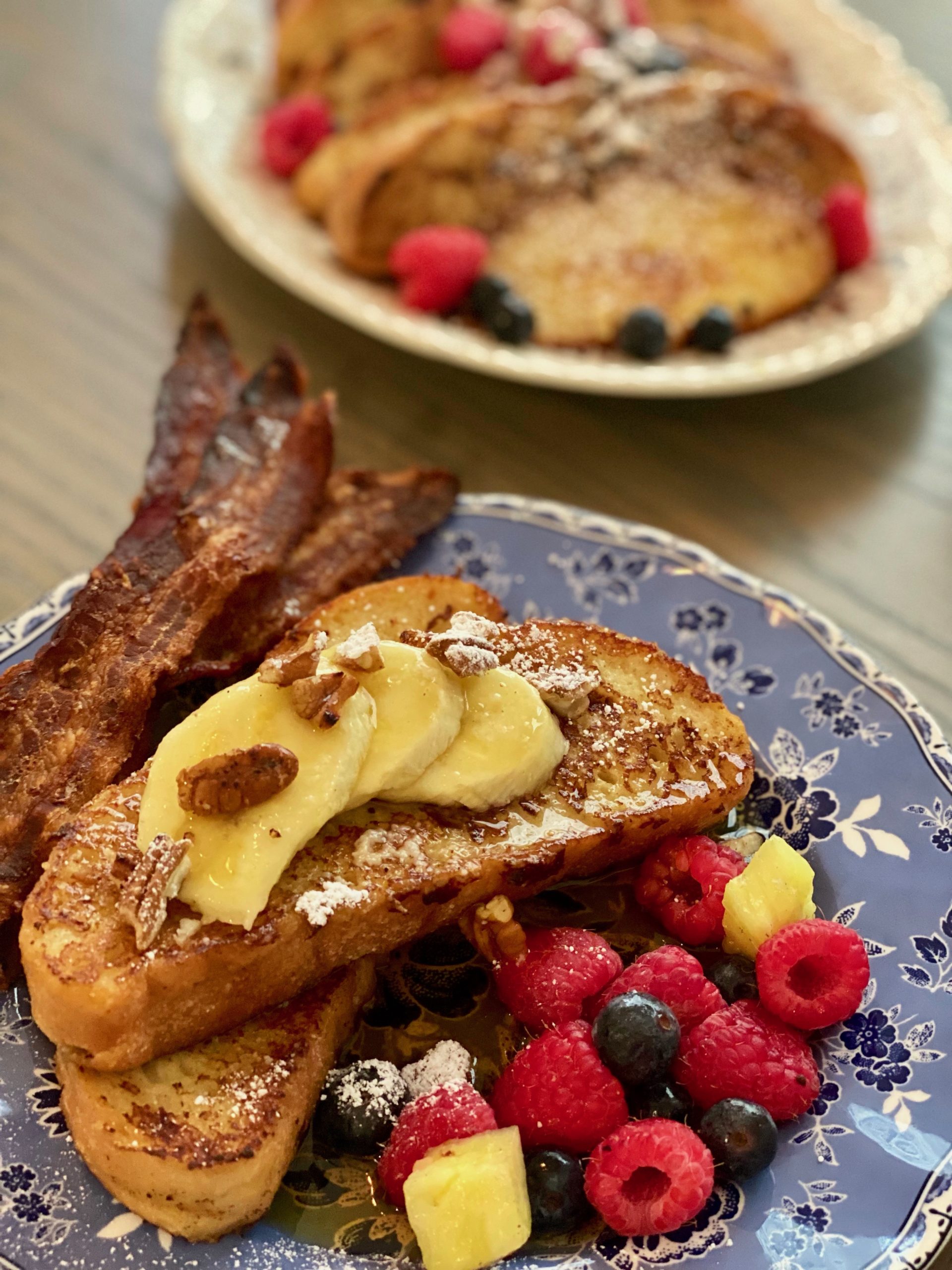 two slices of French toast topped with fruit and nuts