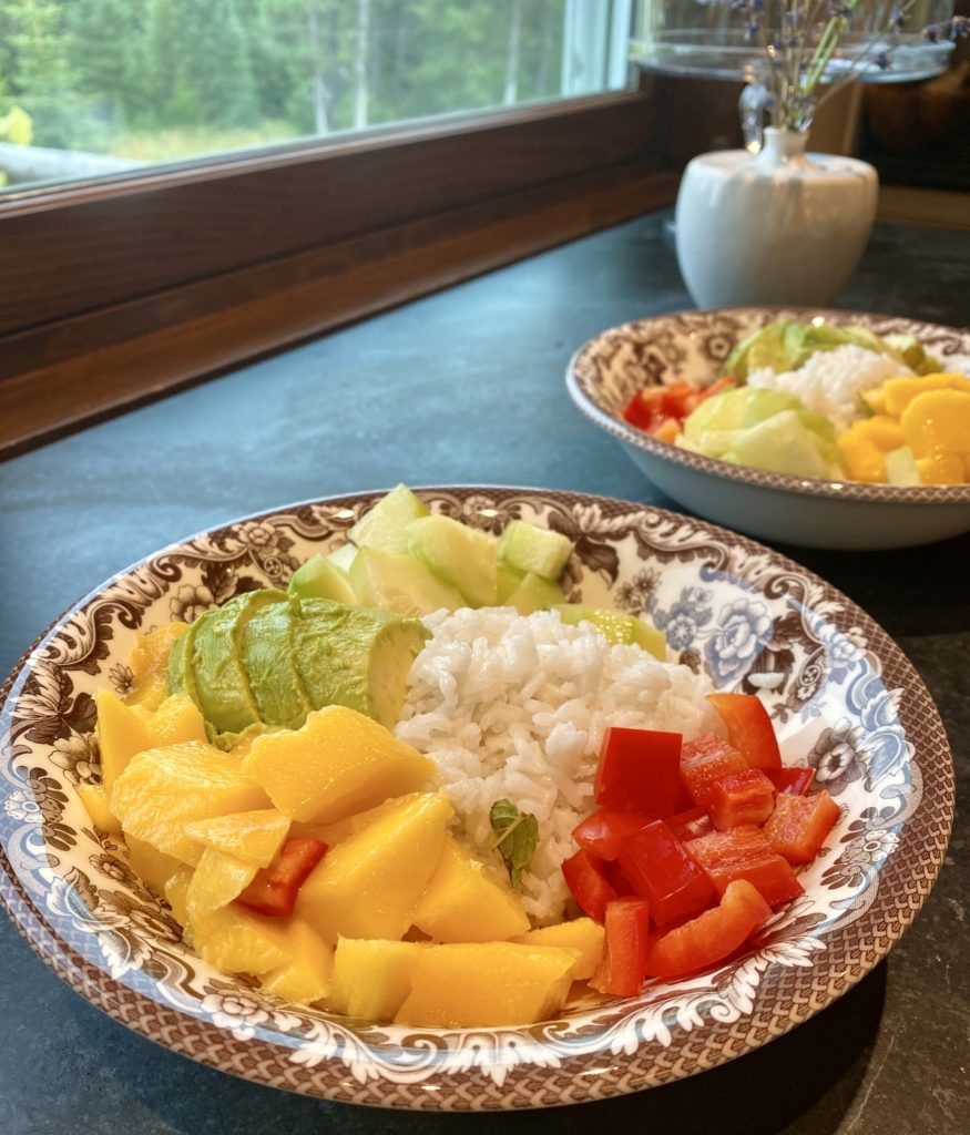 Bowls filled with white rice, chopped mangos, rep bell peppers and avocado 