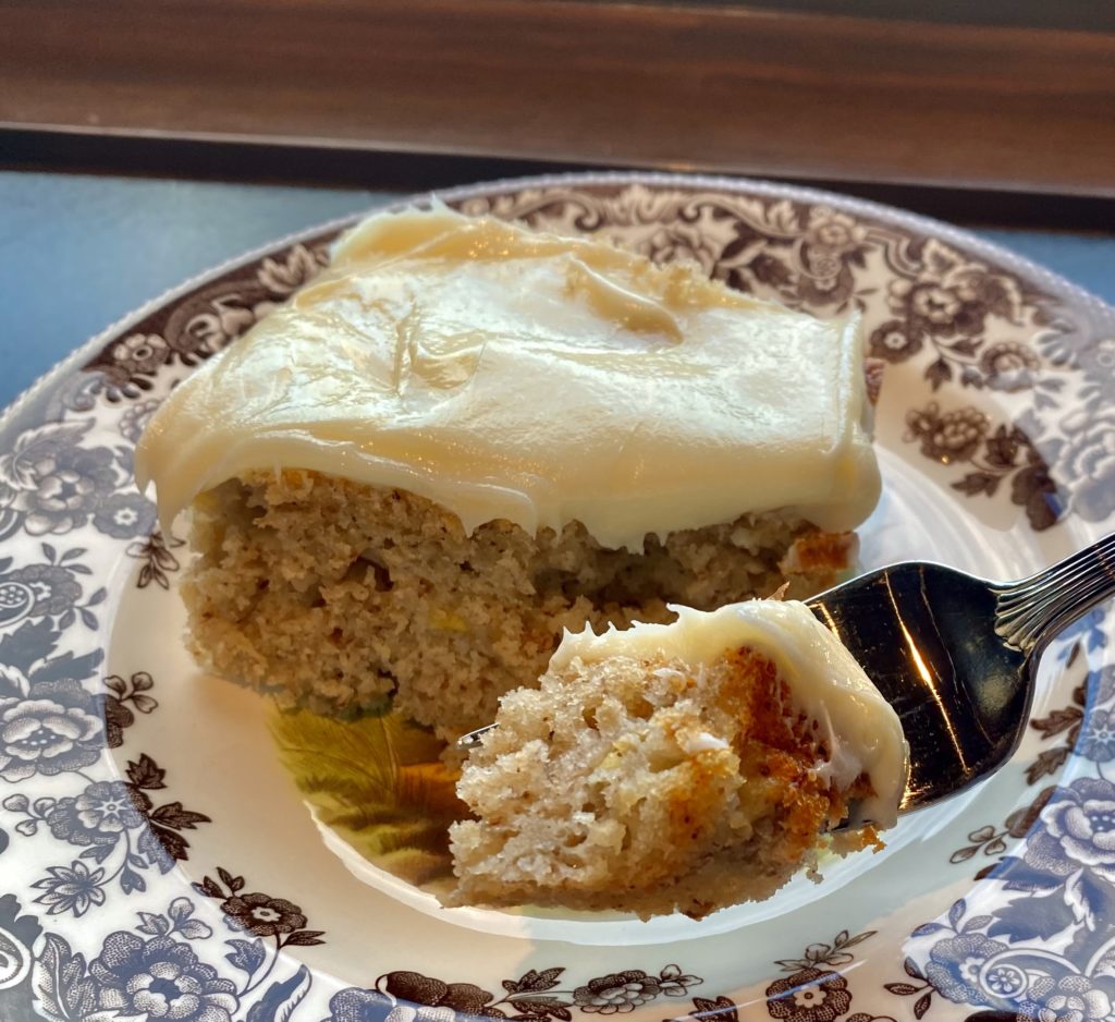 a slice of banana cake with fluffy frosting and a fork