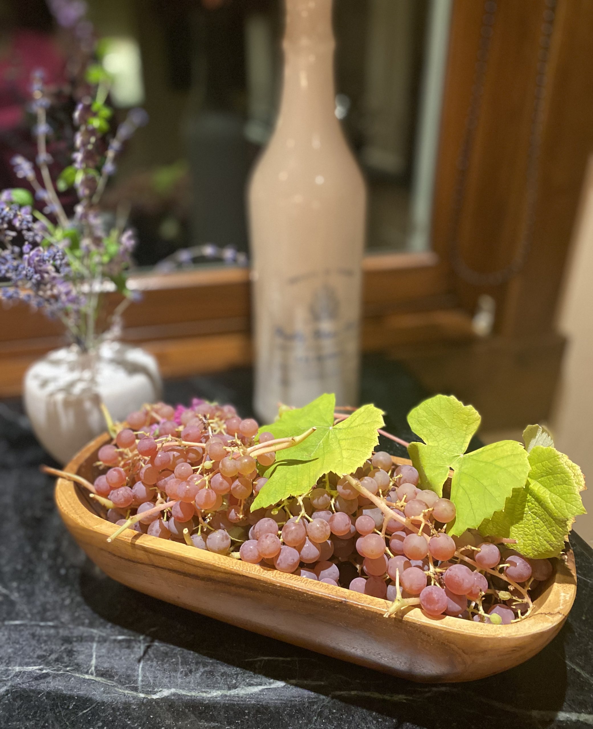 a wooden bowls filled with bunches of grapes