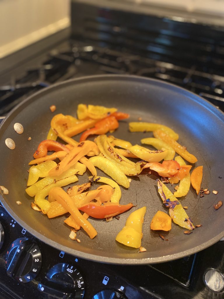 a pan with peppers being sauted 