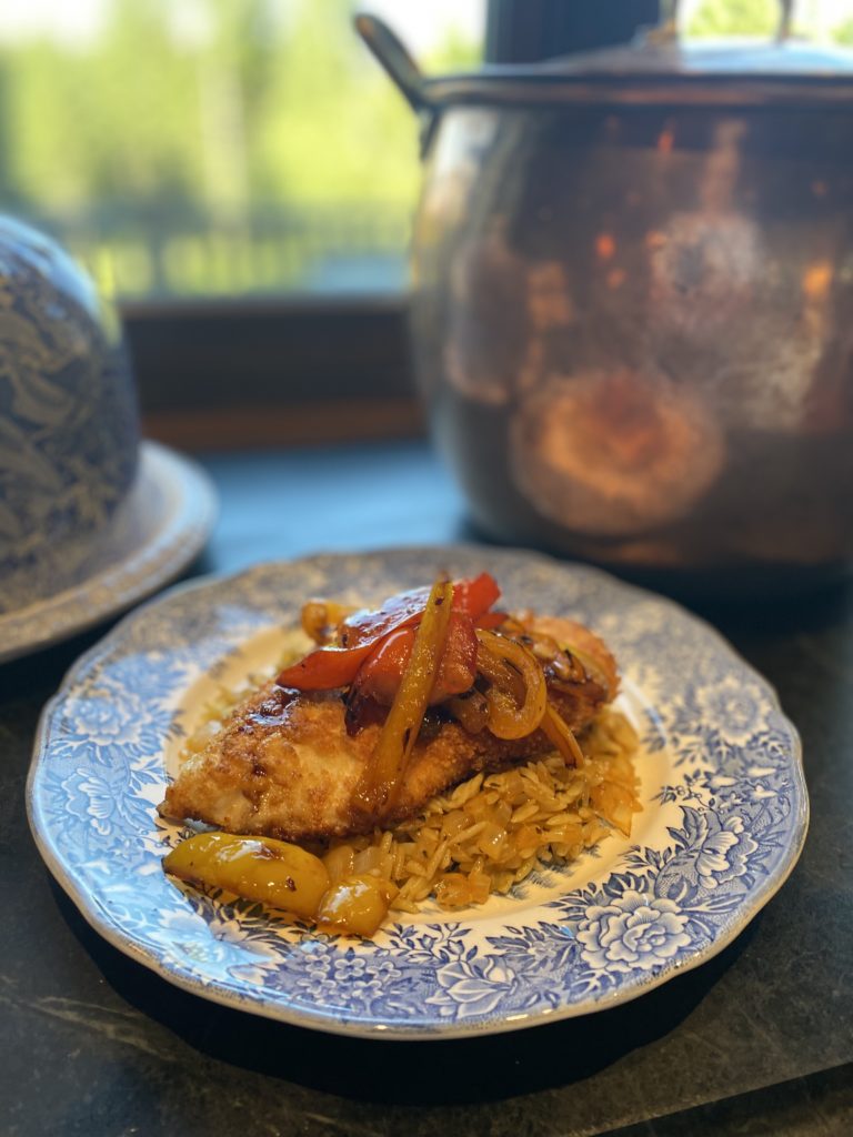 a blue plate with chicken and rice piled high with peppers 
