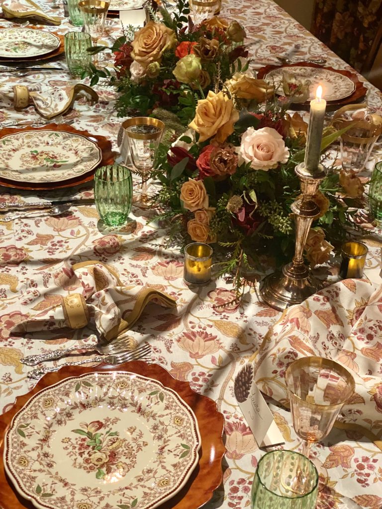 a table elaborately decorated with crystal, china , candlelight and flowers
