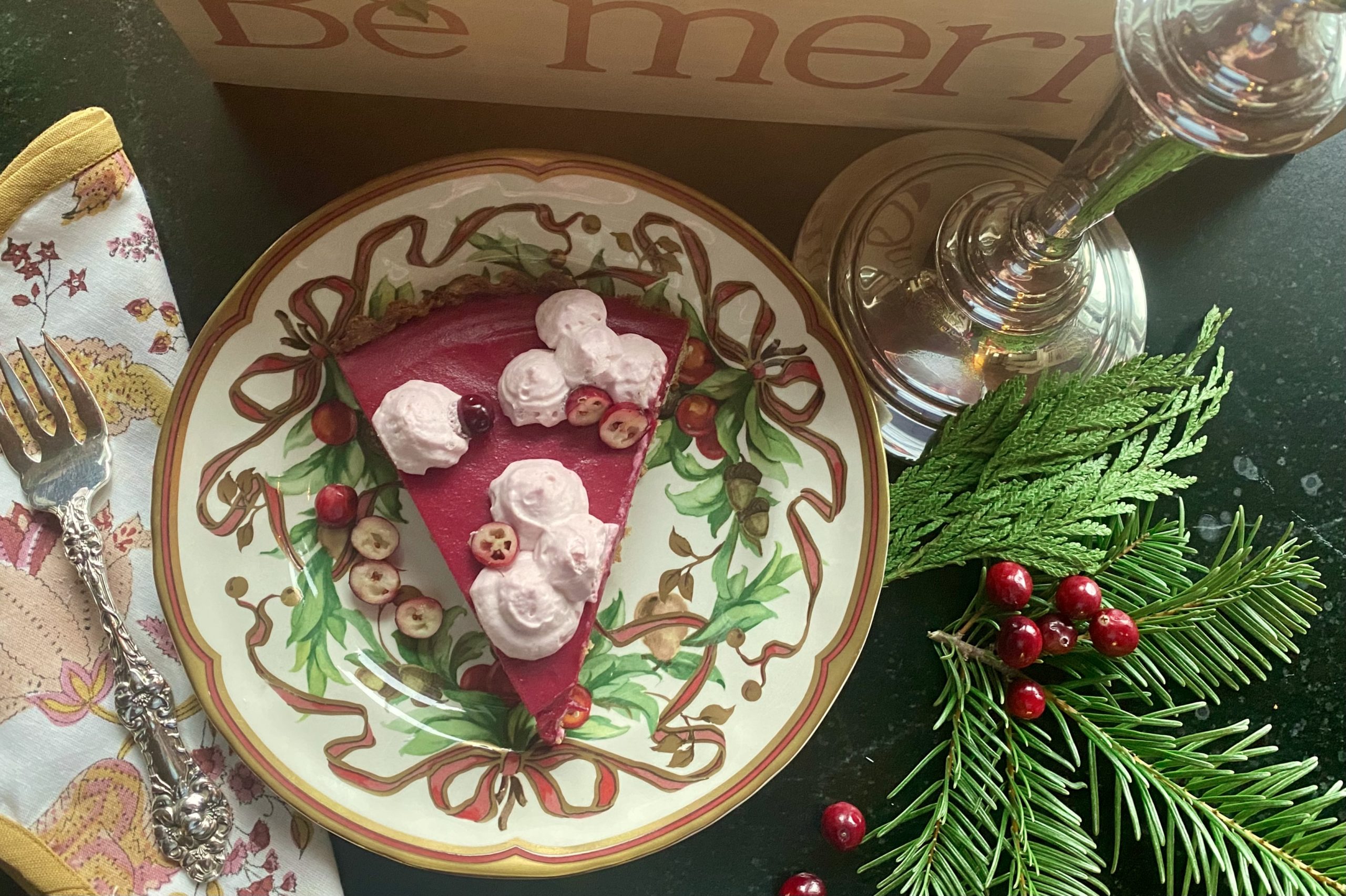 A decorative plate with a slice of cranberry tart on it