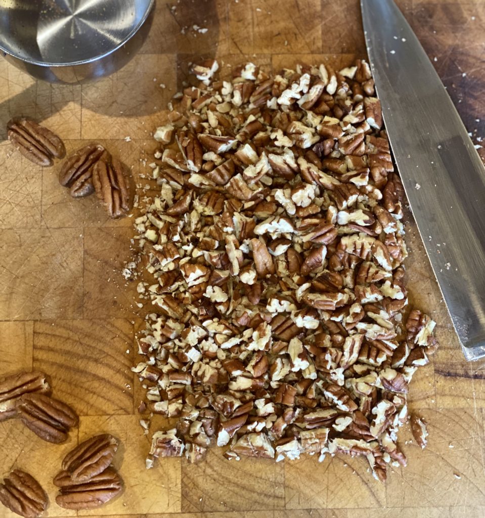 chopped up pecans on a cutting board