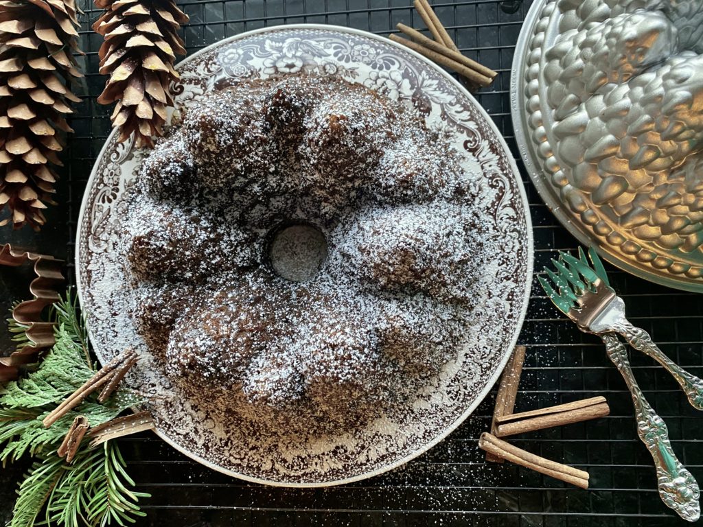 a bundt cake on a plate dusted with powdered sugar 