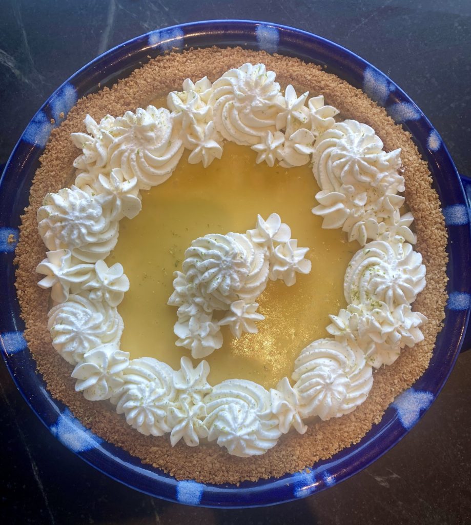 A Key Lime Pie with whipped cream piped on the edges 
