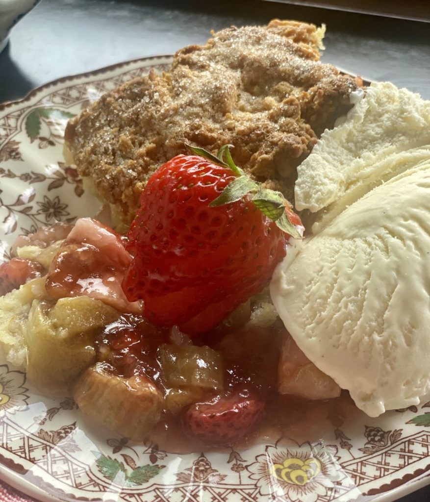 a bowl filled with ice cream topped rhubarb cobbler 