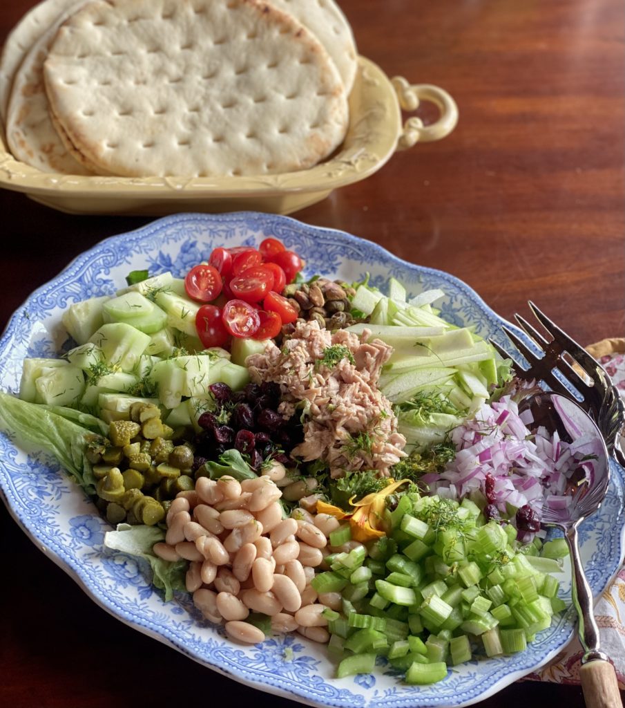 A platter filled with chopped vegetables and a bread