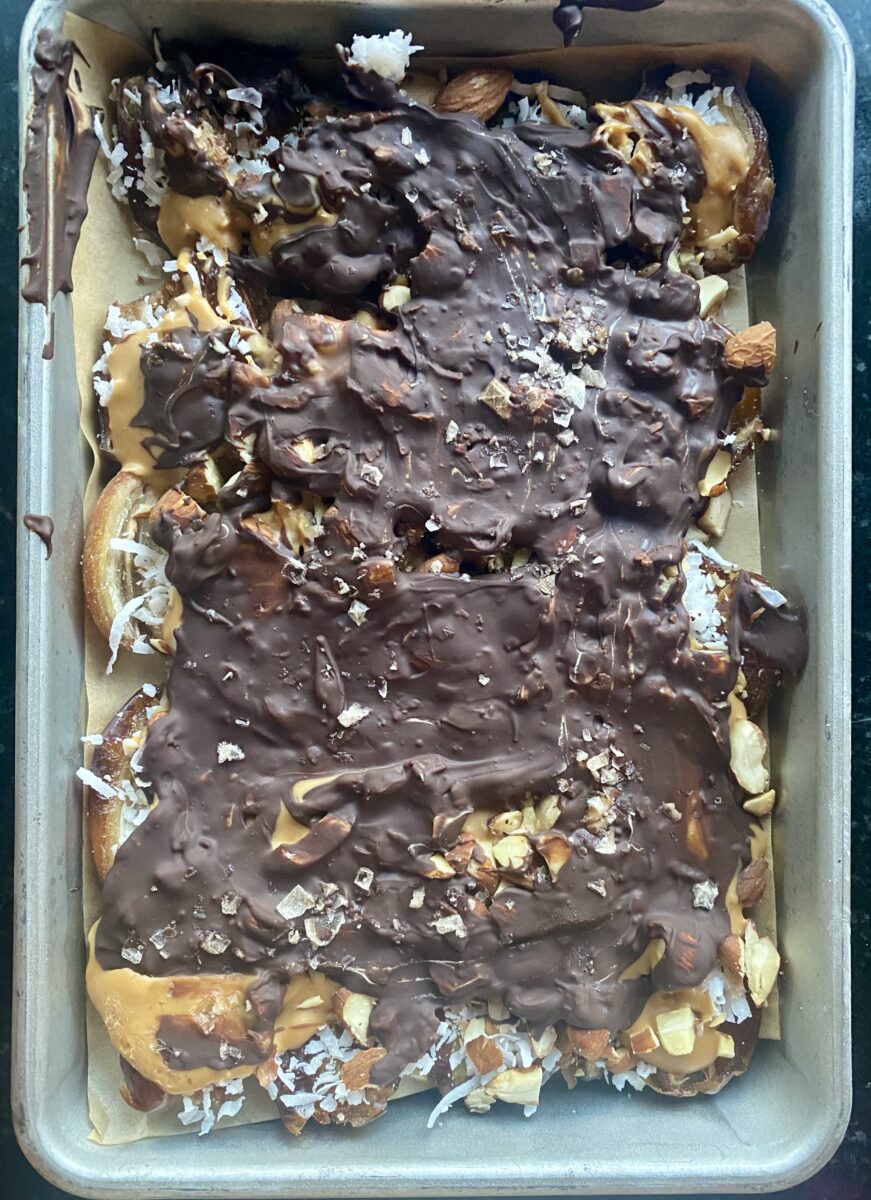 a sheet pan with melted chocolate and dates on it 