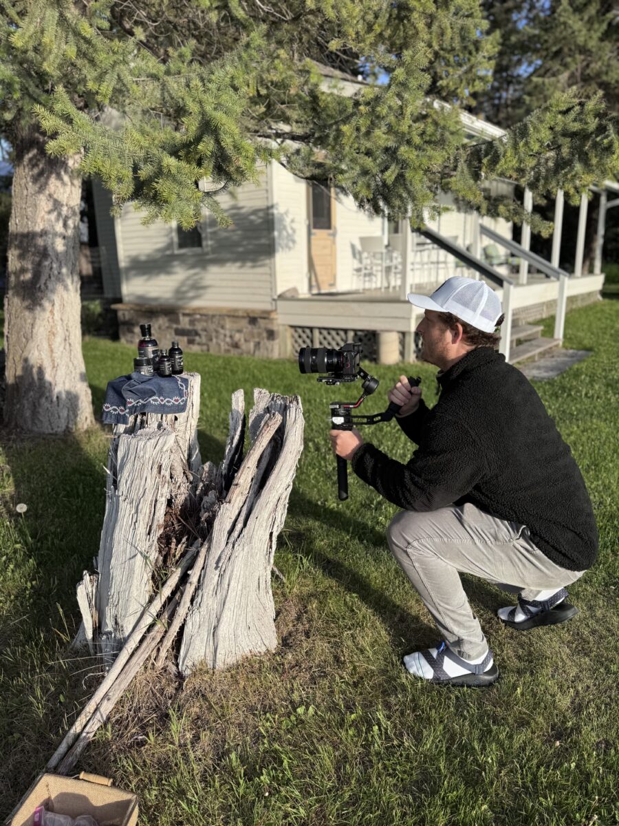 a photographer taking a photo of products on a tree stump 