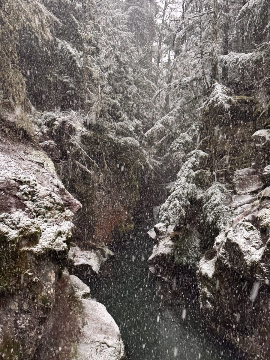 a snowy creek surrounded by massive boulders