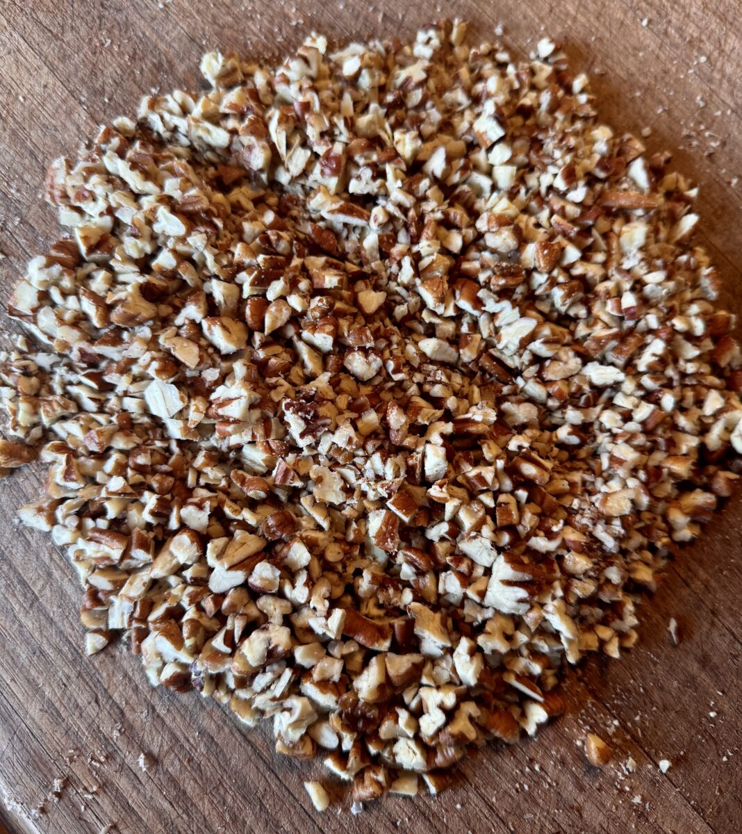 finest chopped pecans on a wooden cutting board 
