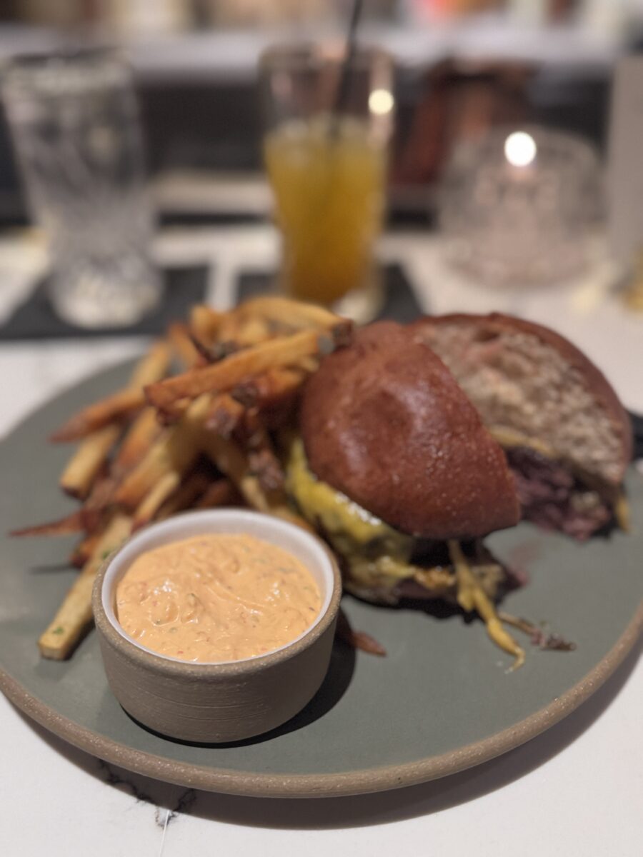a burger with sauce and fries at Herb and Omni in Whitefish Montana 