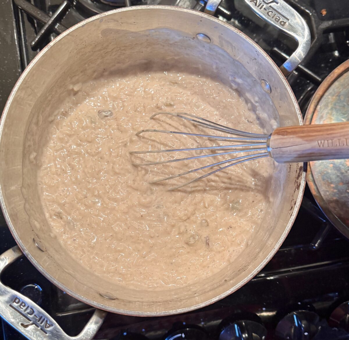 a saucepan filled with creamy vanilla bean rice pudding 