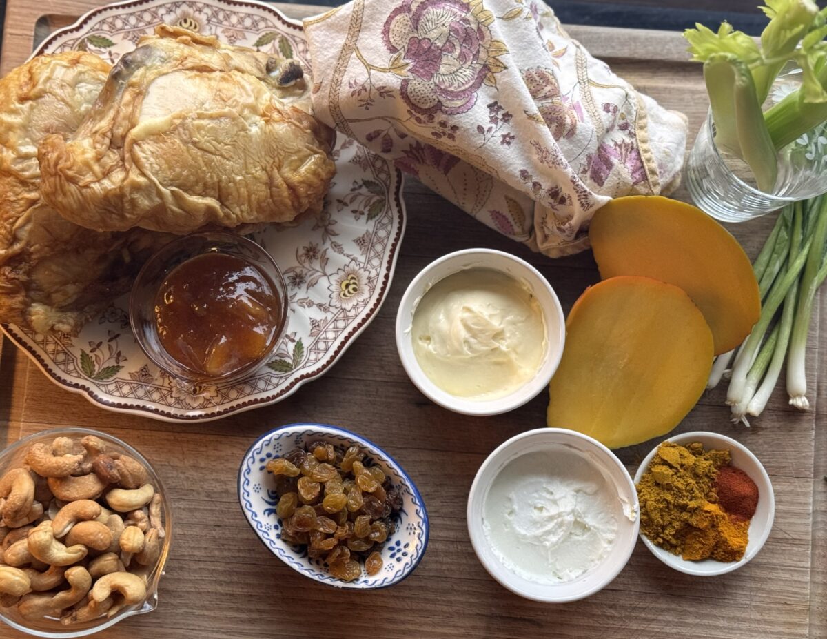 Ingredients for curry chicken salad recipe laid out on a cutting board 