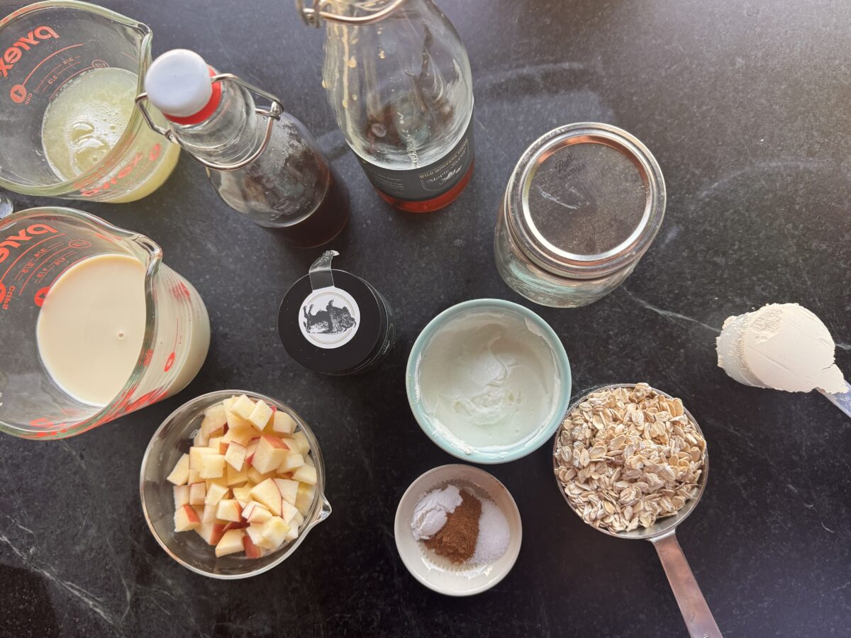 ingredients on a slab of soapstone for baked overnight oats including a scoop of protein powder 
